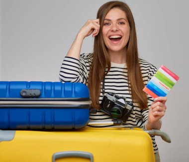 Fotoğraf makinesi olan mutlu kadın bavula yaslanmış. İki büyük seyahat çantalı bir kızın izole edilmiş portresi..