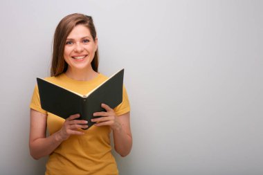 Açık kitabı olan öğrenci kadın gri duvarın yanında izole edilmiş portre..