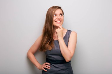 Gülümseyen ofis işleri, elbise giymiş iş kadını düşünüp yukarı bakıyor. münzevi kadın iş adamı portresi.