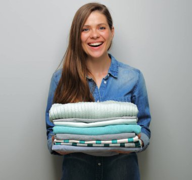 Elbise yığını, çarşaf, havlu, izole edilmiş portre çamaşırları ve otel servisi konsepti olan hizmetçi kadın..