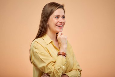 Mutlu düşünen bir kadın, sarı arka planda izole edilmiş bir portre. Uzun saçlı genç bayan. 