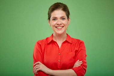 Kırmızı gömlekli, kolları çapraz gülümseyen bir kadın. Yeşil üzerine izole edilmiş kadın portresi.