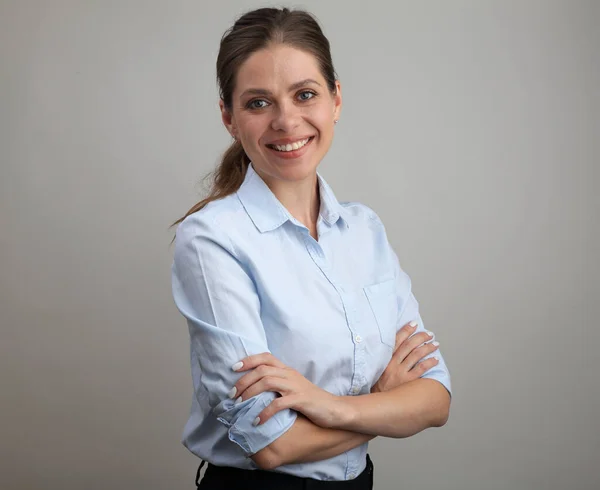 Young woman teacher with crossed arms wearing blue shirt. isolated female portrait.