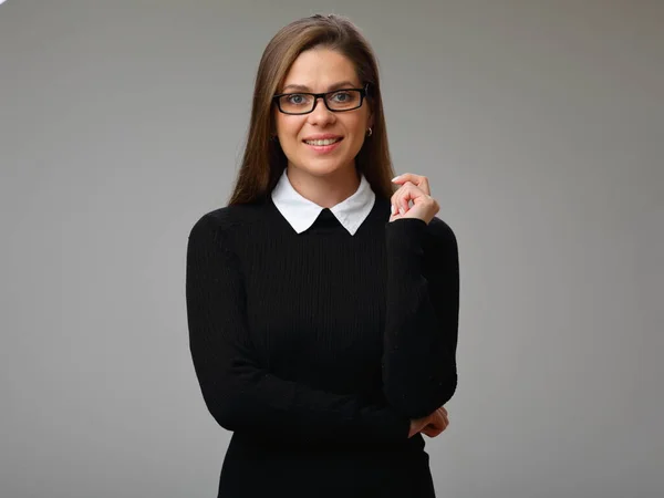 Smiling woman in black business suit with glasses holding hands to cheek, isolated female portrait.