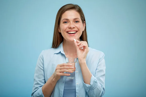 Mujer Sonriente Comiendo Píldora Retrato Aislado Espalda Azul Vaso Agua — Foto de Stock