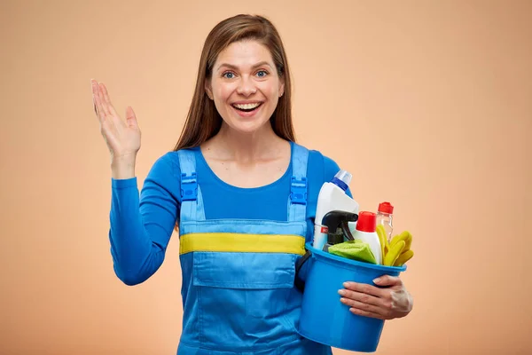 Happy woman in overalls with cleaning products. isolated portrait on brown beige background.