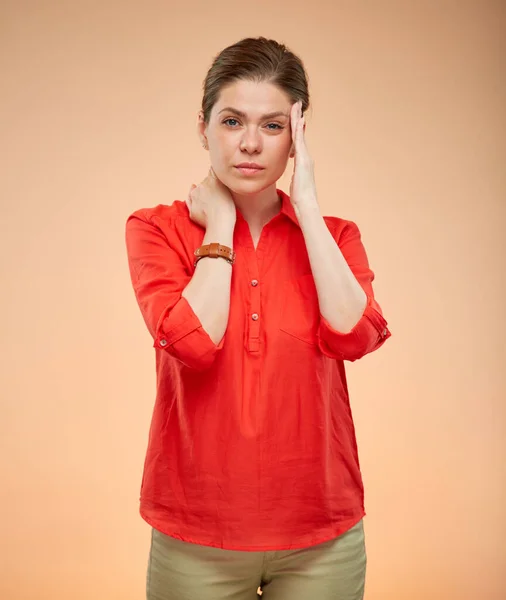 若いです女性の頭に触れる頭痛の種 赤いシャツの女性の孤立肖像画 — ストック写真
