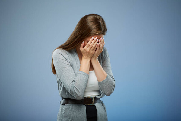 Woman in depression with hands on face. isolated female portrait on blue.