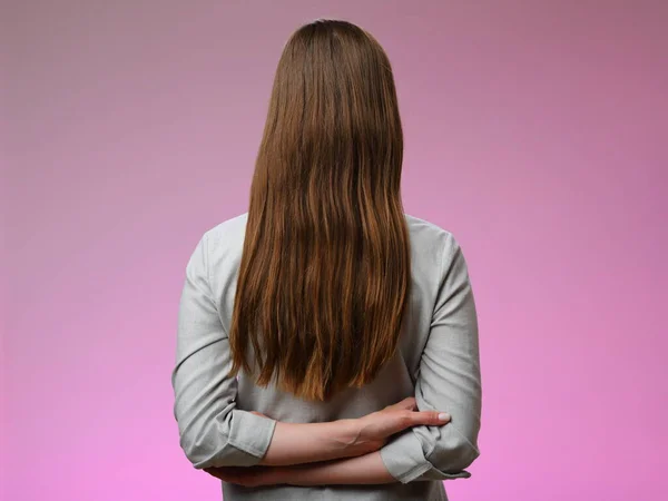 Жінка Довгим Волоссям Стоїть Позаду Ізольована Рожевому — стокове фото