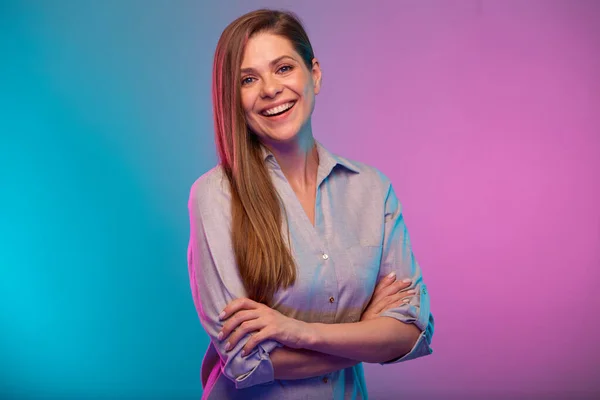 Happy business woman with arms crossed portrait in neon lights. Businesswoman isolated on neon multicolored background.