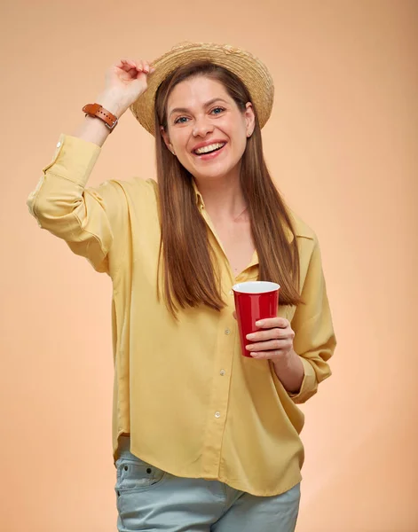 夏の帽子をかぶった幸せな若い女性がコーヒーカップを開催笑顔 黄色の孤立した肖像画 — ストック写真