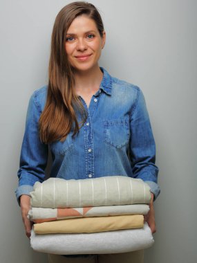 Gülümseyen hizmetçi kadın çamaşır yığını, çarşaf, havlu, izole edilmiş portre otel servis konsepti..