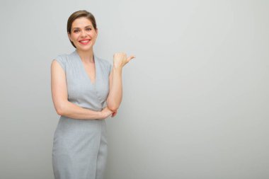 Mutlu gülümseyen iş kadını parmakları kopya yerini gösteriyor, izole edilmiş kadın portresi, gri elbiseli genç iş kadını..