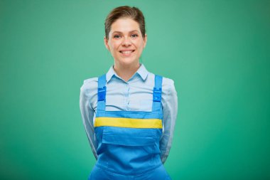 Tulumlu kadın yeşil arka planda tek başına el ele tutuşuyor..