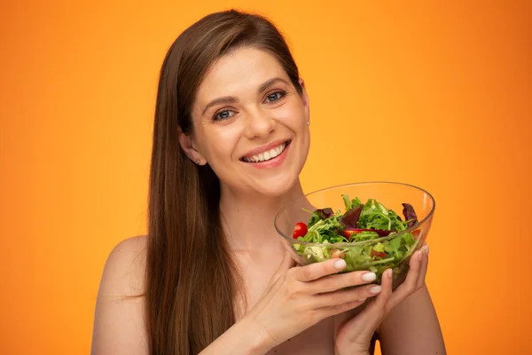Happy laughing woman with bare shoulders holding green salad isolated portrait. Girl with long hair.