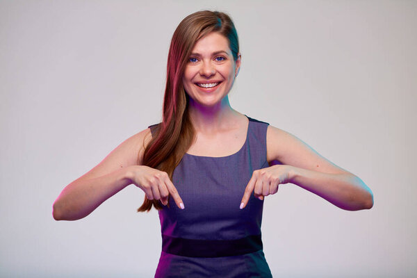 Улыбающаяся деловая женщина, указывающая пальцем вниз, изолированный портрет.