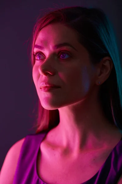 Futuristic look woman with red light, looking away, female face beauty portrait with colored light. natural skin.