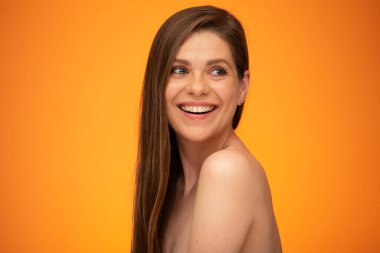 Gülümseyen mutlu kadın omzunun üstünden bakıyor. Uzun saçlı ve çıplak omuzlu bir kız. İzole edilmiş kadın portresi..