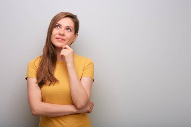 Düşünen bir kadının yukarı baktığını hayal etmek. Sarı gömlekli kadın portresi.