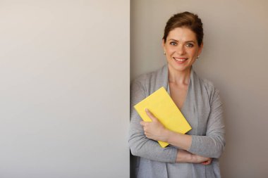 Fotokopi odası olan bir kadın öğretmen. Kız öğrenci kitap tutuyor..