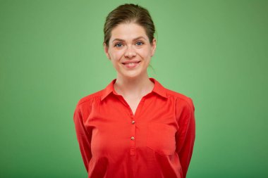 Kırmızı gömlekli gülümseyen genç bayan yeşil stüdyo arka planında izole edilmiş portre..