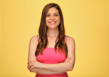 Kameraya bakan gülümseyen kadının ön manzara portresi. Kolları çapraz duran, izole edilmiş sarı sırtında fotokopi alanı olan..