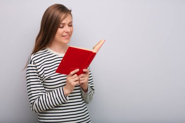 Gülümseyen mutlu genç bayan öğretmen kitap okuyarak izole edilmiş portre  