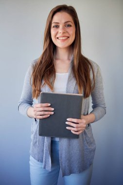 Gülümseyen öğrenci ya da kadın öğretmen gündelik eldiven takıyor. Gri üzerine izole edilmiş portre.