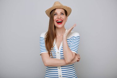 Gülümseyen, şaşırmış bir kadın portresi. Beyaz elbiseli ve hasır şapkalı, duygusal pozlar veren ve yukarı bakan şaşırtıcı bir kız..