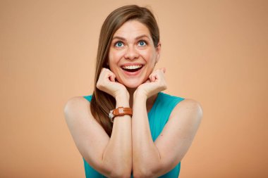 Mutlu duygusal kadın, sarı kahverengi arka planda izole edilmiş portreye bakıyor..