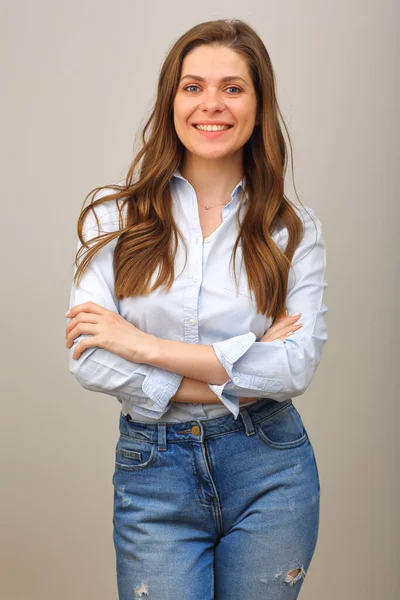 Happy woman with long hair in blue shirt standing with arms crossed. isolated portrait of casual wearing smiling girl.