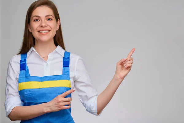 Glimlachende Vrouw Met Blauwe Overalls Wijst Naar Kopieerruimte — Stockfoto