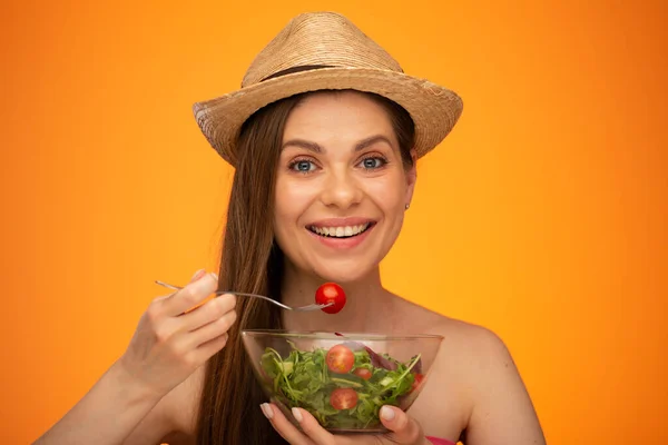 メキシコの帽子を身に着けている裸の肩を持つ笑顔の女性フォークでトマトを食べます 歯で大きな笑顔 孤立した肖像画 女の子顔の肖像画とともに自然な無レタッチ肌 — ストック写真