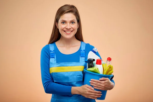 Mavi Tulumlu Gülümseyen Kadın Kovada Temizlik Ürünleri Taşıyor Kahverengi Arkaplanda — Stok fotoğraf