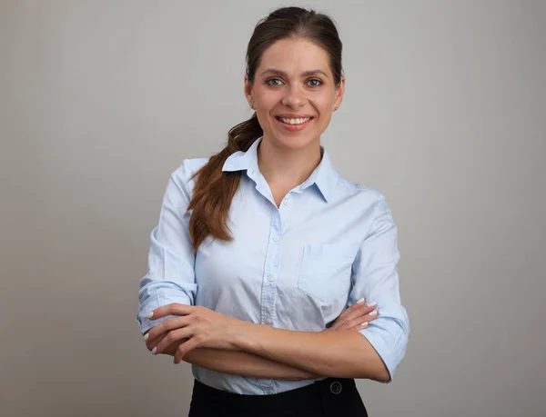 Smiling woman with crossed arms wearing blue shirt. Business woman portrait.