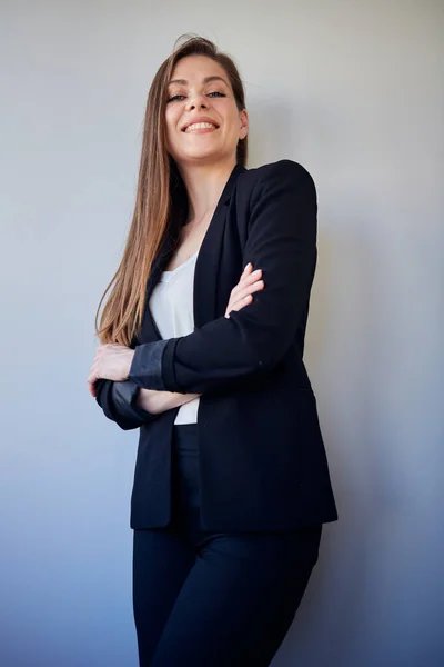 Business woman with long hair in black business suit and white shirt standing with crossed arms. isolated portrait.