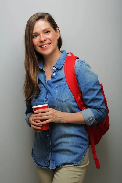 Smiling woman student with red backpack and coffee glass. isolated female portrait.