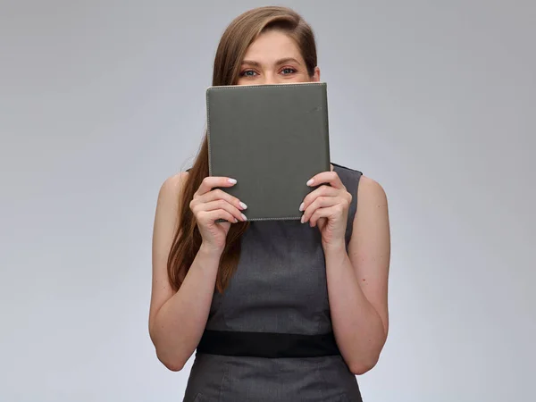 Teacher or student woman covers her face with book. Girl in gray business dress isolated portrait.