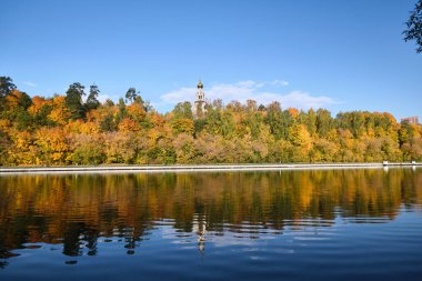 Orman nehri ile sonbahar manzarası. Kilisenin kubbesi ormanda görülebilir..