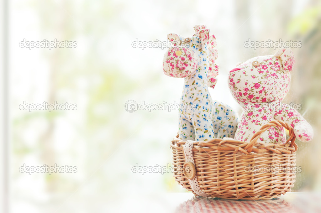 Stuffed horse and bear sitting in basket beside window