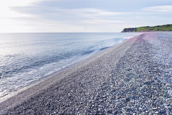 Belle plage avec des cailloux sous la lumière du matin — Photo