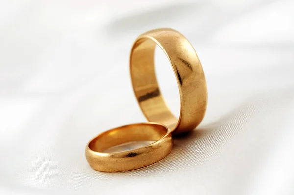 Golden wedding rings on white silk — Stock Photo, Image