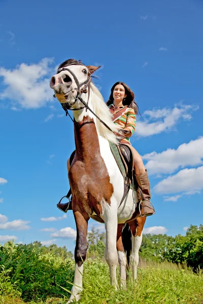 Una joven vestida de india monta un caballo de pintura — Foto de Stock