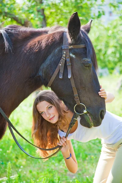 Jong meisje spelen met haar paard. — Stockfoto