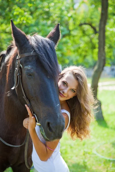 Young girl walking with a horse in the garden. Stock Image