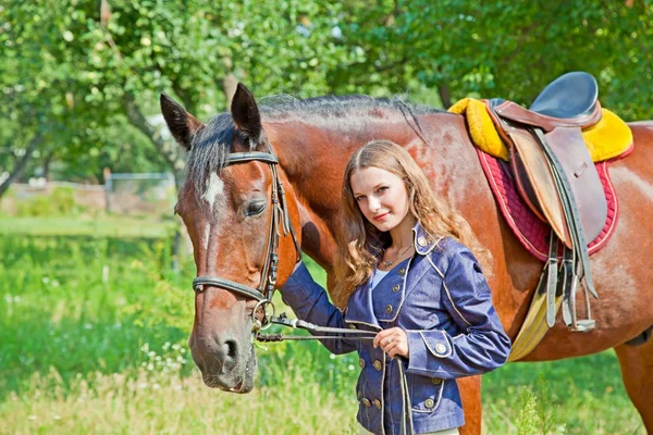 Chica joven caminando en el jardín con un caballo —  Fotos de Stock