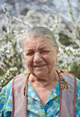 iş giyisi çiçek açması ga karşı gülümseyen yaşlı kadın