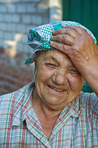 Пожилая смеющаяся женщина в рабочей одежде. Перерыв после работы — стоковое фото