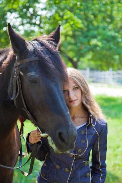 Jeune fille marchant avec un cheval dans le jardin . — Photo
