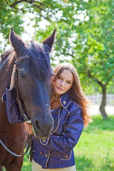 Jong meisje lopen met een paard in de tuin. — Stockfoto